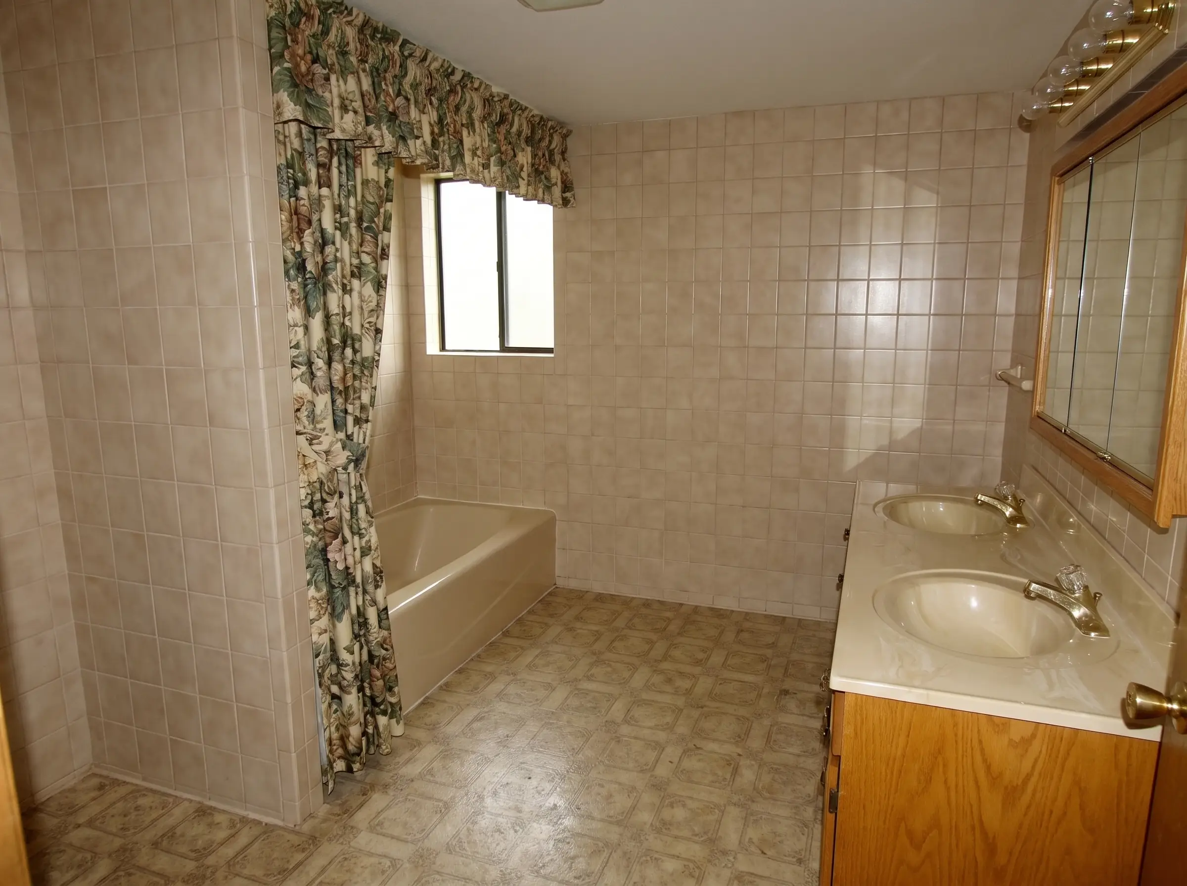Ridgeview bathroom before renovation: dated beige tile and oak vanity