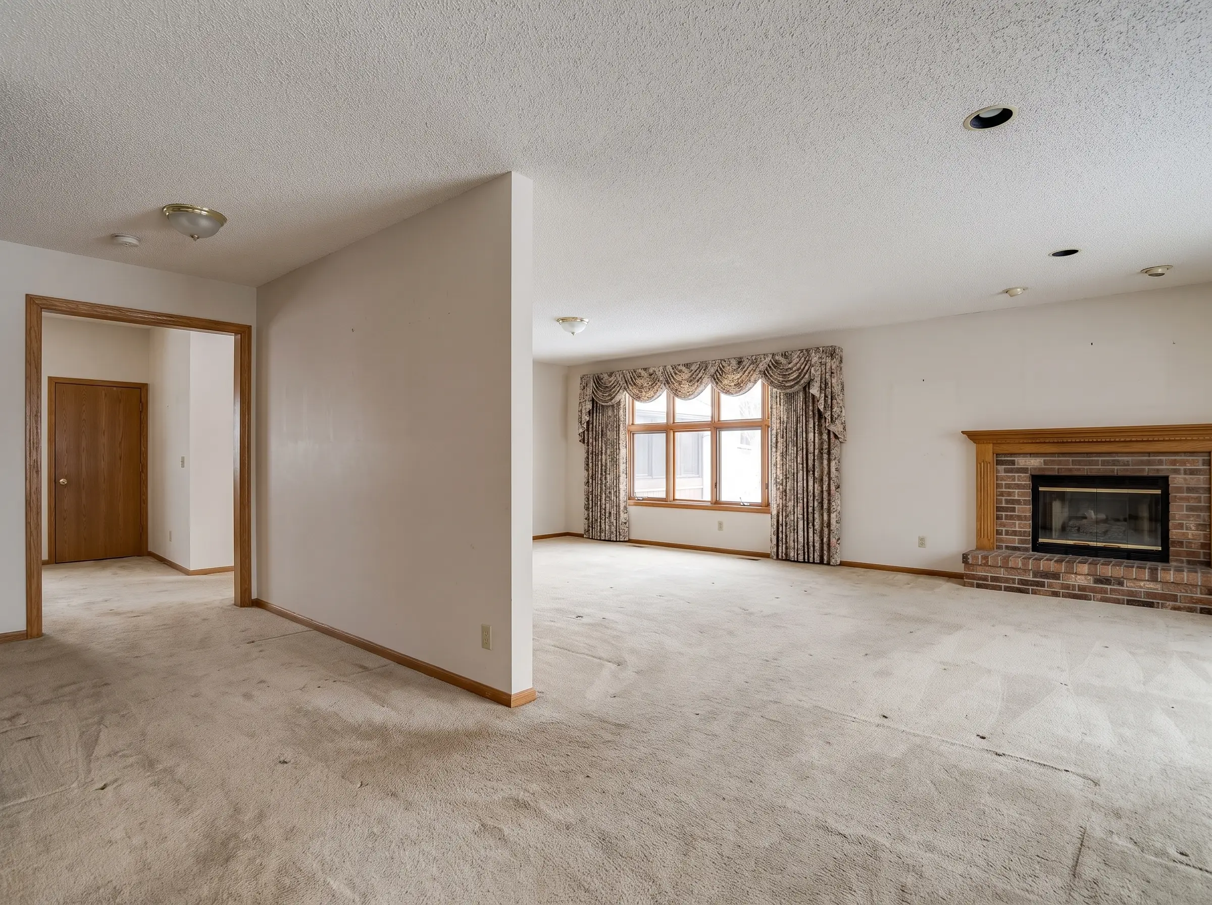 Main floor before renovation: dividing wall and dated carpet